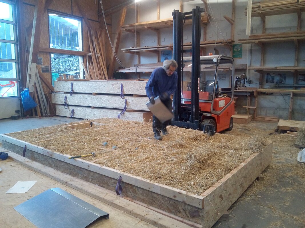 mur ossature bois paille en cour de remplissage